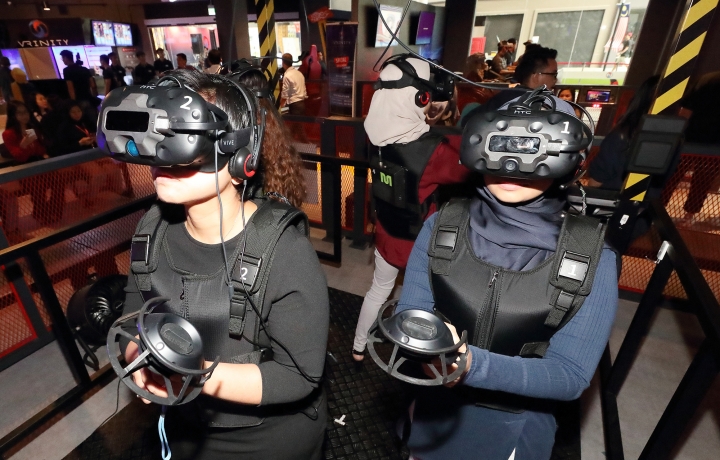 KT와 IISB가 함께 구축한 말레이시아 VR 테마파크 ‘브리니티’에서 방문객이 VR 어트랙션과 게임을 체험하고 있다.[사진=KT]