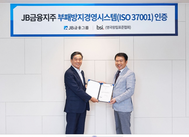 JB금융그룹 김기홍 회장(왼쪽)이 BSI 코리아 송경수 총괄 책임으로부터 지난 30일 서울 여의도 JB빌딩에서 'ISO 37001' 인증서를 수여받고 있다. [사진=JB금융지주]