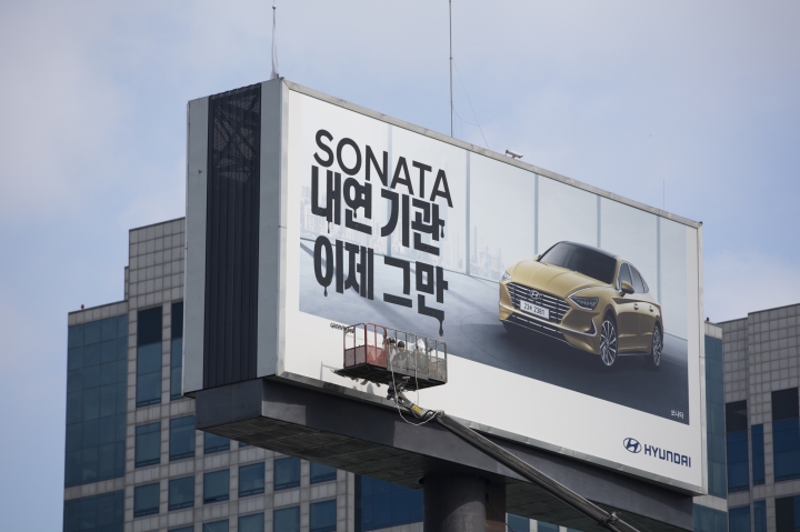 그린피스가 지난 15일 오전 서울 서초구 양재동 현대자동차 사옥 인근 대형 현대차 광고판에 내연 기관차 생산 중단을 촉구하는 스티커를 부착했다. [연합뉴스]