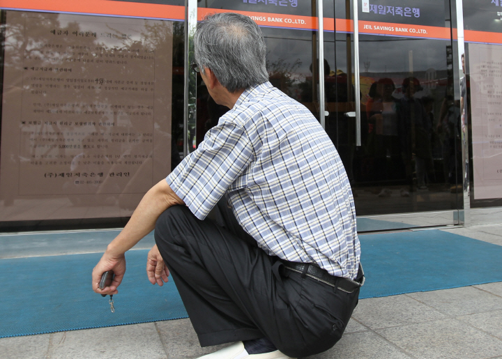 서울시 송파구에 위치한 한 은행 앞에 노인이 앉아있다.[연합뉴스]