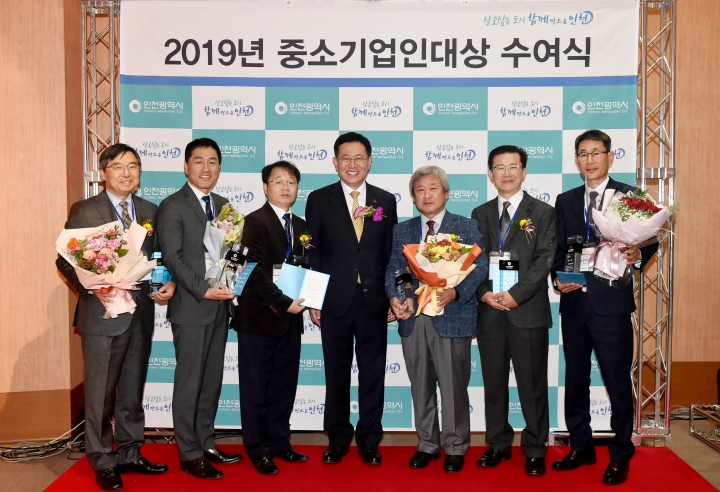 박남춘 인천시장(가운데)이 6일 송도 갯벌타워에서 열린 '2019 하반기 우수기업 인증서 수여식'에서 수상자들과 기념촬영을 하고 있다.