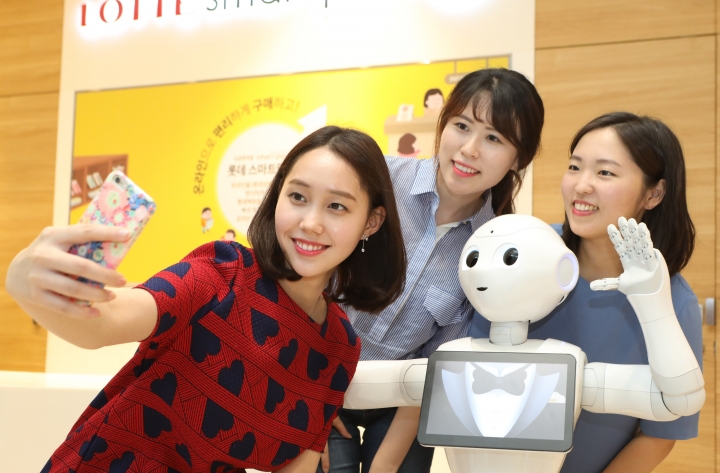 인공지능 로봇 '페퍼'가 롯데백화점에서 고객들과 함께 사진을 촬영하고 있다. [사진=롯데백화점]