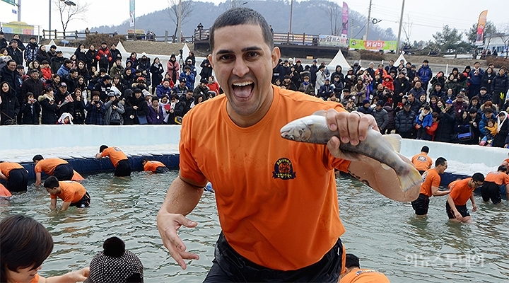 2019화천산천어축제 맨손잡기 프로그램에 참여한 외국인이 산천어를 잡고 포즈를 취하고 있다.