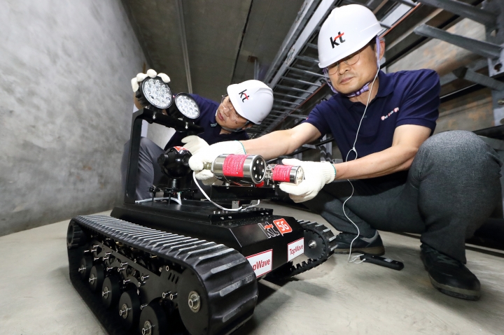 KT 네트워크부문 직원들이 통신구에 설치된 지상형 5G 로봇을 점검하고 있다.[사진=KT]