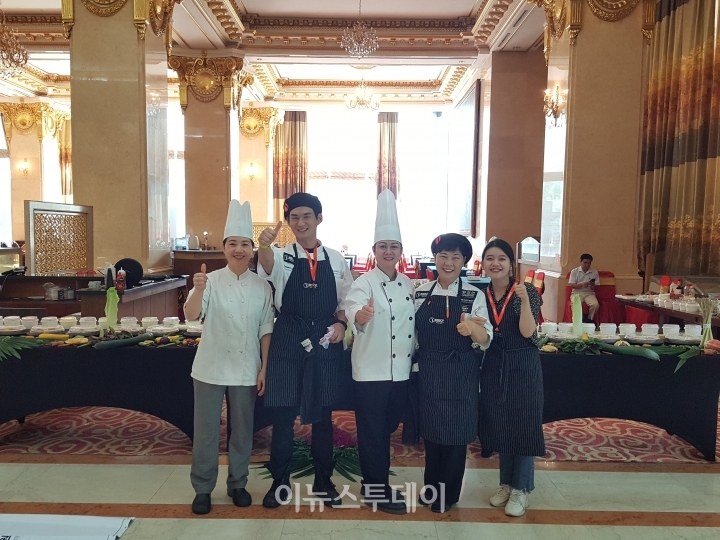 지난 10월 베트남에서 열린 한식홍보행사에 참가한 엄신현 군(사진 좌측 두번째)이 현지 요리사 스텝들과 함께 한 모습.(사진=이용준 기자)