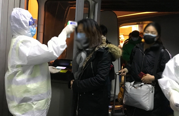 지난 22일(현지시간) 중국 우한에서 온 승객들을 대상으로 한 베이징 공항 당국의 체온 검사를 진행하고 있다. [사진=연합뉴스]