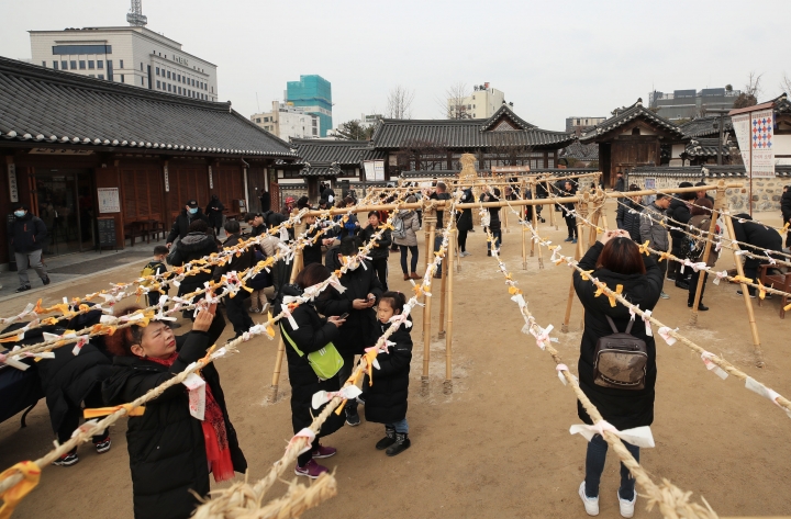 설날인 25일 서울 남산골한옥마을에서 시민들이 직접 작성한 소원지를 묶고 있다. [사진=연합뉴스]