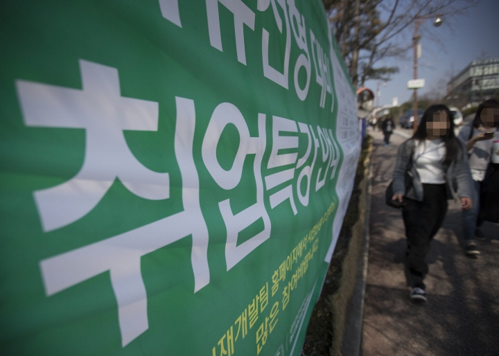 서울의 한 대학에서 학생들이 취업 관련 내용이 적힌 현수막 앞을 걸어가고 있는 모습.[사진=연합뉴스]