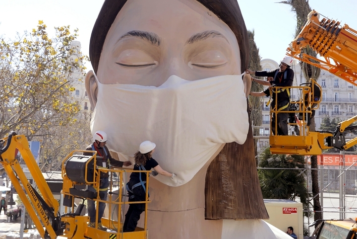 스페인 발렌시아의 한 축제 현장에 설치된 조각상에 11일(현지시간) 인부들이 마스크를 씌우고 있다. [사진=연합뉴스]