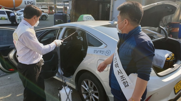 성남시 개인택시조합원들이 갈현동 LPG충전소를 찾은 택시를 소독하고 있다. [사진=성남시]