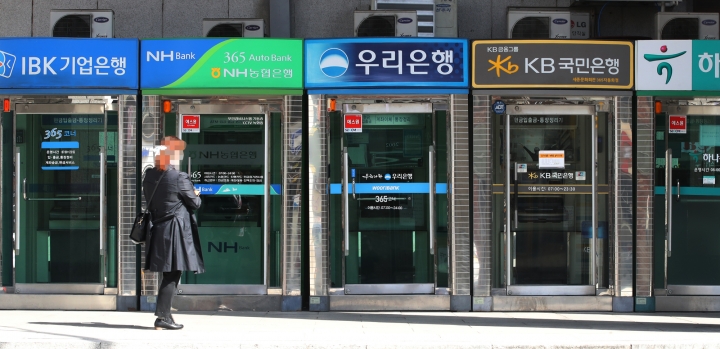 서울 광화문 세종문화회관에 설치된 현금자동입출금기(ATM) 앞을 시민들이 지나고 있다. [사진=연합뉴스]