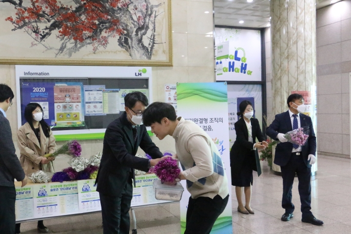 8일, LH경남지역본부에 출근하는 직원들에게 꽃을 나눠주고 있다.[사진=밀양시]