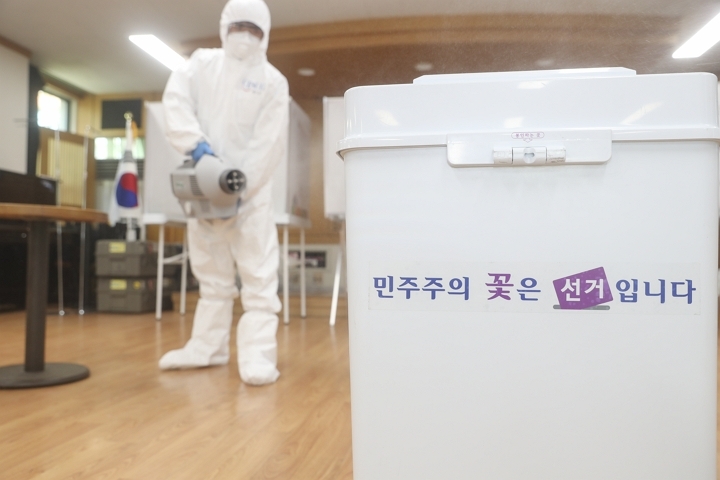 제21대 국회의원 선거를 하루 앞둔 14일 서울 성동구 관계자가 코로나19 감염을 막고자 투표소에 방역작업을 하고 있다. [사진=성동구]