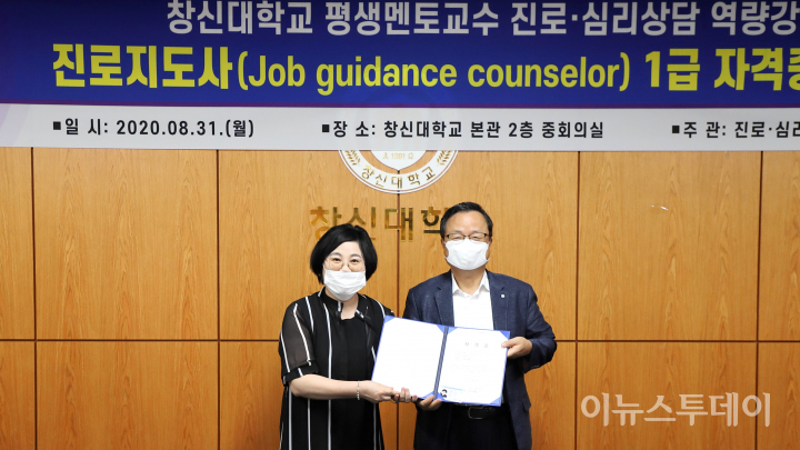 이원근 총장이 교수 대표인 김혜윤 교육혁신원장에게 자격증을 전달하고 있다