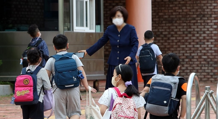 한 초등학교에서 교장 선생님이 학생을 맞이하고 있다. [사진=연합뉴스]