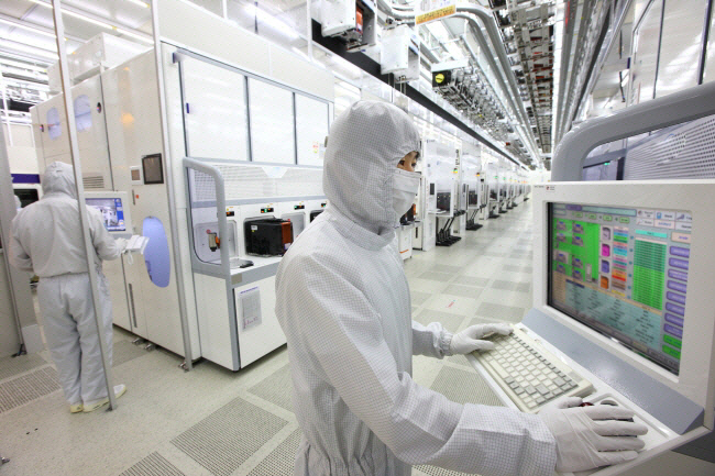 삼성전자 반도체 생산라인에서 한 엔지니어가 설계 모니터를 살펴보고 있다. [사진=삼성전자]