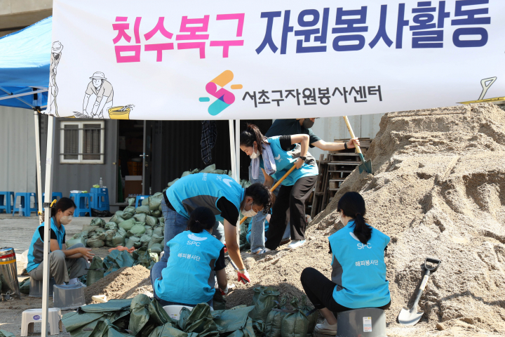 SPC그룹 임직원이 12일 서울 서초구 반포종합운동장에서 하천 범람 방지를 위한 모래주머니를 제작하고 있다. [사진=SPC]