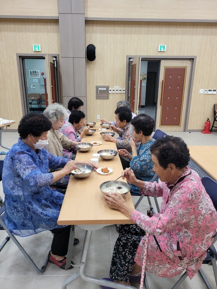 어르신들이 초동면 자원봉사회가 전달한 삼계탕으로 식사를 하고 있다. [사진=밀양시]