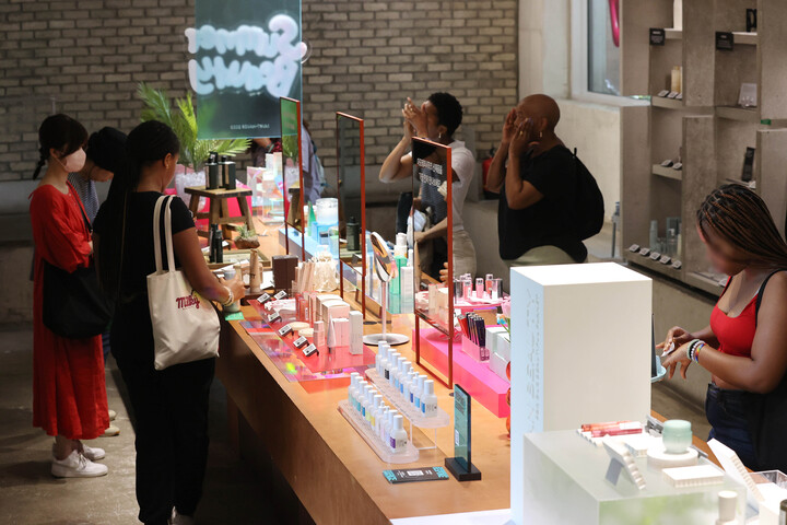서울의 한 화장품 전시장을 찾은 외국인들이 제품을 테스트하는 모습. [사진=연합뉴스]