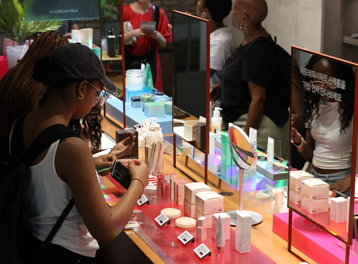 서울의 한 화장품 전시장을 찾은 외국인들이 제품을 테스트하는 모습. [사진=연합뉴스]