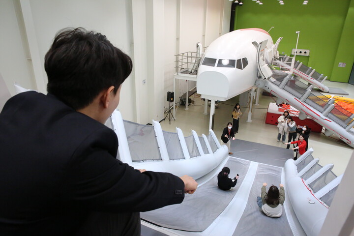 지난 22일 오후 티웨이항공 훈련센터에서 세이브더칠드런을 통해 초청한 아동·청소년이 A330 항공기 슬라이드 훈련을 체험하고 있다. [사진=티웨이항공]