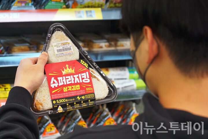 11일 오후 서울 강남구의 한 CU 편의점 매장에서 한 시민이 최근 출시한 ‘슈퍼라지킹 삼각김밥’을 바라보고 있다. [사진=안경선 기자] 