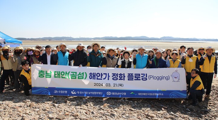 지난 21일 충남 태안군 곰섬 해안 일대에서 ‘해안가 환경정화 플로깅’ 참가자들이 다함께 기념촬영을 하고 있다.[사진=Sh수협은행]