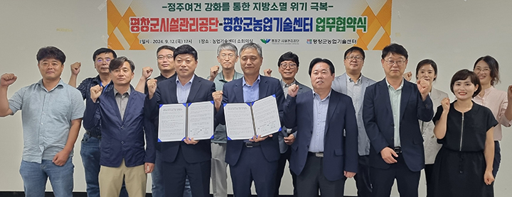 최순철 평창군시설관리공단 이사장과 허목성 평창군농업기술센터 소장이 12일 센터 소회의실에서 귀농·귀촌 지원을 위해 업무협약을 맺고 참석자들과 기념촬영을 하고 있다. [사진=평창군시설관리공단]