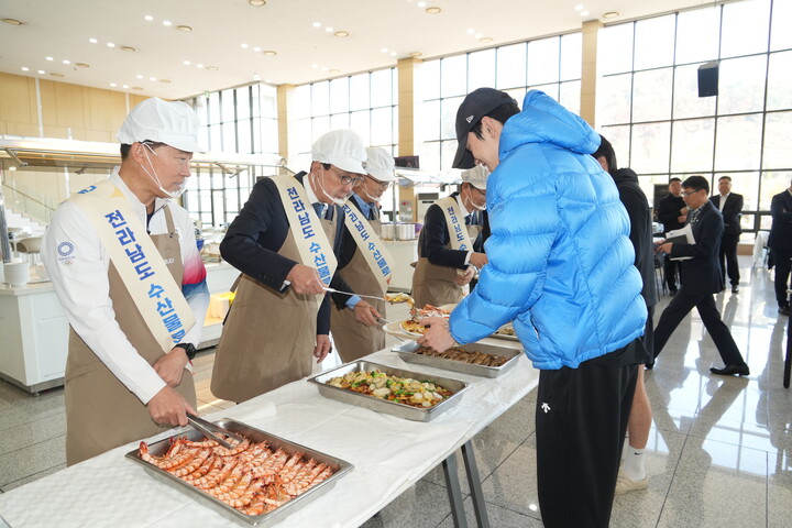 노동진 수협중앙회장(왼쪽 두번째)이 12일 충북 국가대표선수촌에서 열린 수산물 전달 행사에서 내년 동계올림픽 출전을 앞둔 선수단에게 수산물 특식을 직접 배식하며 선수들을 격려하고 있다. [사진=수협중앙회]