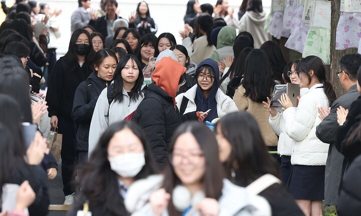 지난 12일 오전 경남 창원시 마산합포구 성지여자고등학교에서 고3 수험생이 교사와 후배의 응원을 받으며 교정을 나서고 있다. [사진=연합]