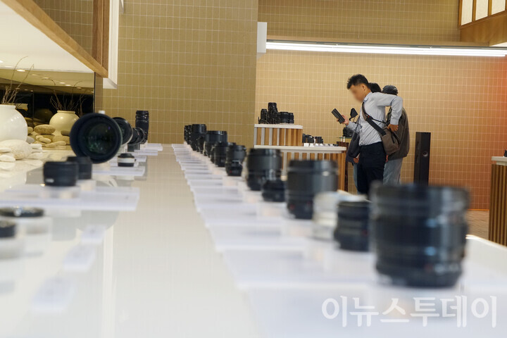 17일 오후 서울 용산구 ‘후지필름 하우스 오브 포토그래피’에서 한 방문객이 진열된 카메라 렌즈 사이에서 사진을 찍고 있다. [사진=이뉴스투데이DB]